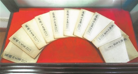 Fanned volumes of the Su Weigong Wenji, the collected writings of Su Song, displayed on red cloth.